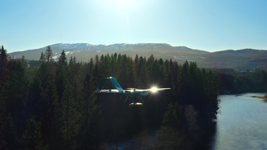 A winged drone flies over a wilderness area
